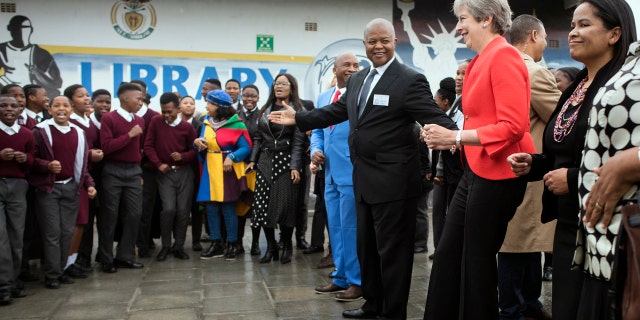 British Prime Minister Theresa May, second from right, dances with pupils during a visit at the the ID Mkhize High School in Gugulethu, Cape Town, South Africa, Tuesday, Aug. 28, 2018.
