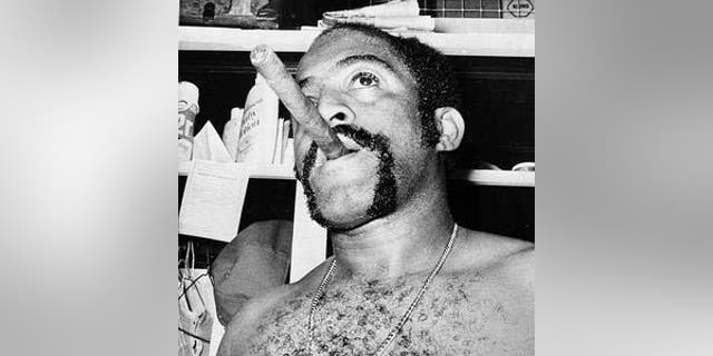 Cuban-born pitcher Luis Tiant smokes what he called a Cuban cigar in the Red Sox dressing room after he pitched a 6-0 win over the Cincinnati Reds in the 1975 World Series opener. Tiant was part of a wave of MLB players in the late 1950s and early 1960s who were signed to clubs before the U.S. trade embargo was imposed on Cuba in 1962.