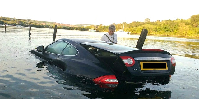 This picture shows the moment an expensive Jaguar was consumed by water - after the owner left the car parked on a tidal road. See SWNS story SWJAG; The black Jaguar XK, which cost around Â£60,000 when new, can be seen with the boot open and water nearly to the top of the windows. Chris and Gill Freeborn were passing in their boat when they spotted the unfortunate situation, and quickly took some snaps. Gill said the sight made her "howl with laughter", and Chris said the Jaguar was "clearly not a happy pussy cat". The car, worth around Â£10,000 on the current market, has now been removed from Aveton Gifford tidal road in Kingsbridge, Devon.