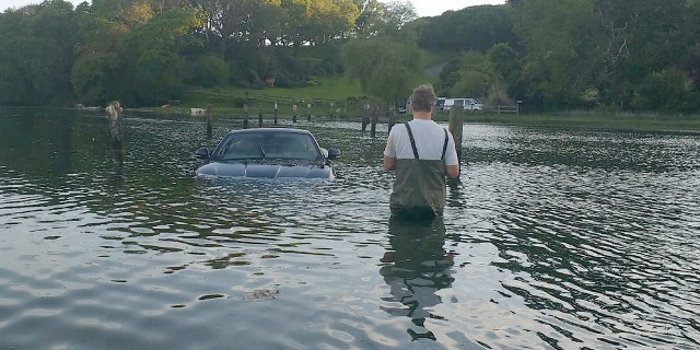 This picture shows the moment an expensive Jaguar was consumed by water - after the owner left the car parked on a tidal road. See SWNS story SWJAG; The black Jaguar XK, which cost around £60,000 when new, can be seen with the boot open and water nearly to the top of the windows. Chris and Gill Freeborn were passing in their boat when they spotted the unfortunate situation, and quickly took some snaps. Gill said the sight made her "howl with laughter", and Chris said the Jaguar was "clearly not a happy pussy cat". The car, worth around £10,000 on the current market, has now been removed from Aveton Gifford tidal road in Kingsbridge, Devon.