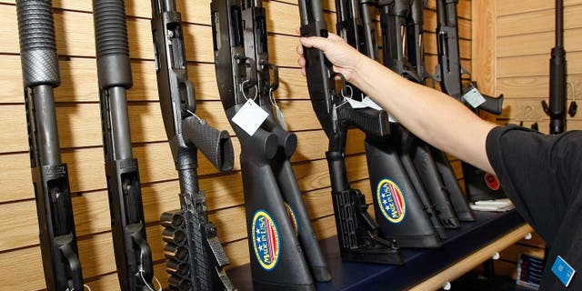 LAS VEGAS - NOVEMBER 14: A sales associate takes a gun from a display of shotguns at The Gun Store November 14, 2008 in Las Vegas, Nevada. Store manager Cliff Wilson said he's seen a large spike in sales since Barack Obama was elected president on November 4, with customers citing fears about the president-elect's record on firearms. The election, combined with a slumping economy, has contributed to an overall increase of 25-30 percent in gun sales at the store, Wilson said. (Photo by Ethan Miller/Getty Images)