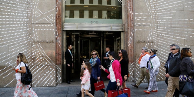 Shoppers walk by Tiffany & Company's Fifth Avenue store in New York.