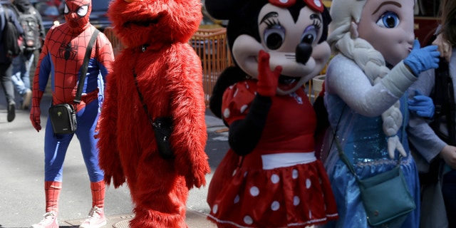 Costumed characters work for tips in Times Square.