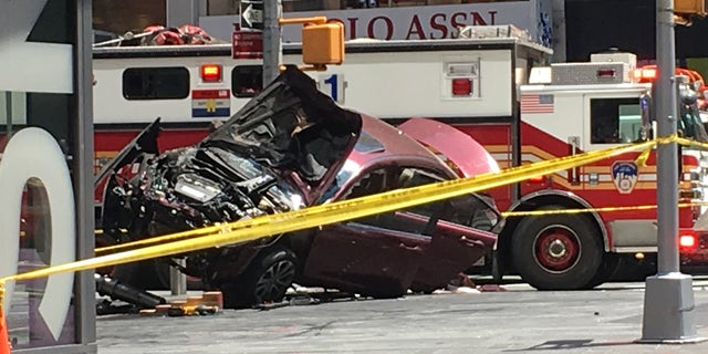 A smashed car sits on the corner of Broadway and 45th Street in New York's Times Square after driving through a crowd of pedestrians