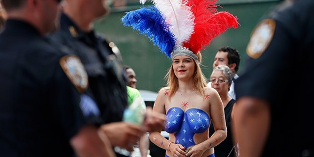 A painted lady in Times Square walks near a group of police officers.