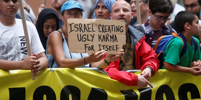 An anti Israel protester holds up a sign during a demonstration in Times Square in the Manhattan borough of New York City, New York, U.S. June 23, 2017. REUTERS/Carlo Allegri - RC125AE1E000