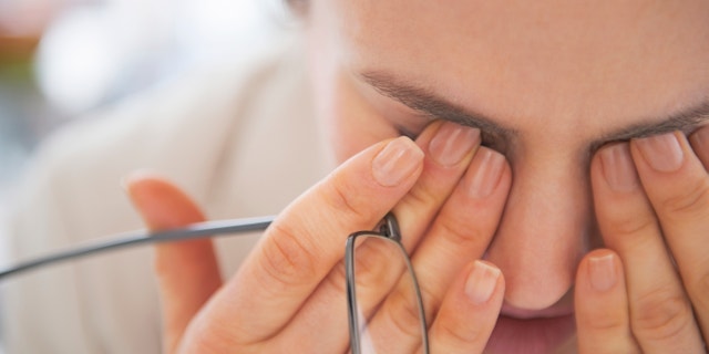 Closeup on tired business woman with eyeglasses