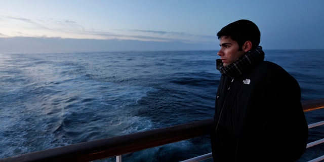 A passenger of MS Balmoral Titanic memorial cruise ship, gazes out to the Atlantic Ocean, following a memorial service, marking the 100-year anniversary of the Titanic disaster, in the early hours of Sunday, April 15, 2012.