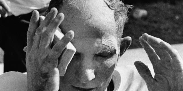 In this Oct. 7, 1962, file photo, New York Giants quarterback Y.A. Tittle wipes his face after running for a touchdown against the St. Louis Cardinals, in St. Louis.