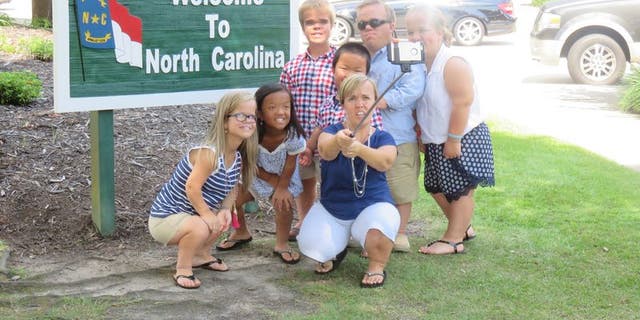 The Johnston family taking a selfie at the North Carolina state border sign.