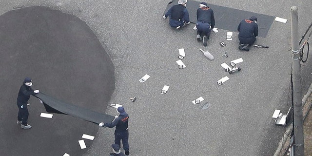 June 26, 2018: Investigators work at an elementary school after a man fatally shot a security guard, in Toyama, northwest of Tokyo.