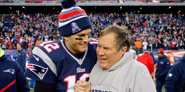 Dec 14, 2014; Foxborough, MA, USA; New England Patriots quarterback Tom Brady (12) celebrates with head coach Bill Belichick (R) after clinching the AFC East title with a 41-13 win over the Miami Dolphins at Gillette Stadium. Mandatory Credit: Winslow Townson-USA TODAY Sports