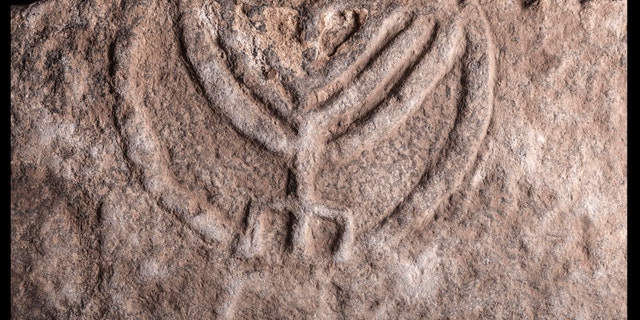 Detail of carved menorah on tomb door.