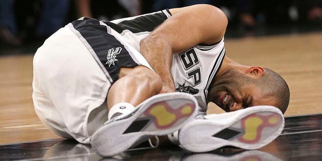 In this Wednesday, May 3, 2017 photo, San Antonio Spurs' Tony Parker holds his left leg after getting injured in the second half of Game 2 of the Western Conference semifinals at the AT&T Center against the Houston Rockets in San Antonio. The Spurs announced on Thursday, May 4, 2017, that Parker has a ruptured quadriceps tendon in his left leg. (Jerry Lara/The San Antonio Express-News via AP)