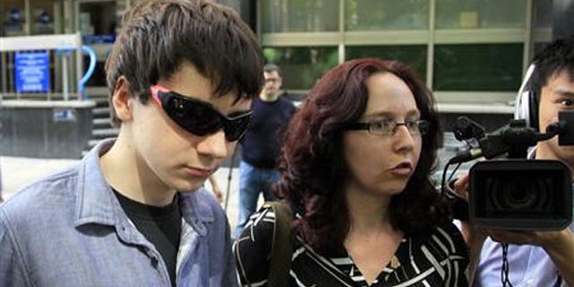 August 1, 2011: Suspected British computer hacker Jake Davis (L) leaves City of Westminster Magistrates' Court in London after being released on bail.