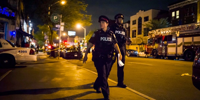 Police secure a perimeter around the scene of a mass shooting in Toronto on Monday, July 23, 2018. (Christopher Katsarov/The Canadian Press via AP)