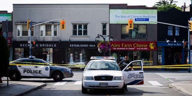 Police are shown at the perimeter of the scene of a shooting in east Toronto, on Monday, July 23, 2018. Police were trying Monday to determine what prompted a 29-year-old man to go on a shooting rampage in a popular Toronto neighborhood. (Christopher Katsarov/The Canadian Press via AP)