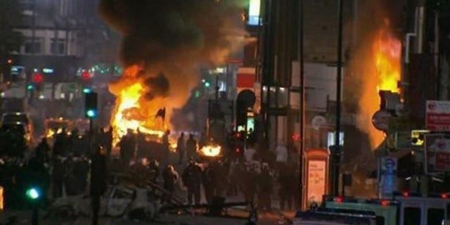 Aug. 6: In this image from video, a bus and shop burn in Tottenham, north London after two police cars were attacked by members of a community where a young man was shot dead by police on Thursday.