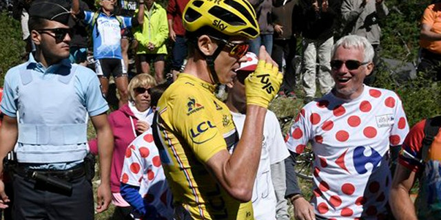 Britain's Chris Froome, wearing the overall leader's yellow jersey reacts after he crashed at the end of the twelfth stage of the Tour de France cycling race Thursday, July 14, 2016. (Jeff Pachoud/ Pool Photo via AP)