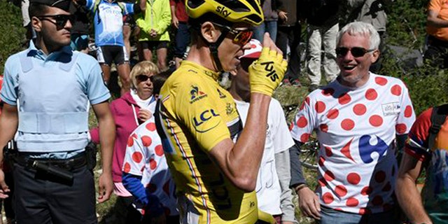 Britain's Chris Froome, wearing the overall leader's yellow jersey reacts after he crashed at the end of the twelfth stage of the Tour de France cycling race Thursday, July 14, 2016. (Jeff Pachoud/ Pool Photo via AP)