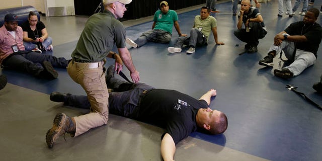 June 3, 2014: Houston police officer Austin Huckabee, left, uses officer Thomas Emmite, Jr, to show other officers how to apply a tourniquet at the police academy in Houston.