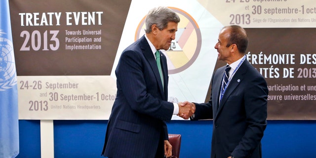 U.S. Secretary of State John Kerry, left, shakes hands with Under Secretary-General for Legal Affairs Miguel Serpa Soares after signing the Arms Trade Treaty.