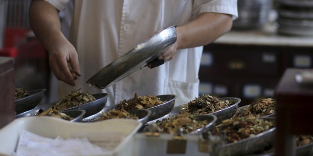 An employee works at a traditional Chinese medicine shop in Shanghai, China, September 16, 2015. (REUTERS/Aly Song)