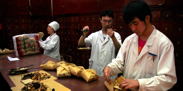 Workers prepare traditional Chinese herbal medicines at Beijing's Capital Medical University Traditional Chinese Medicine Hospital May 25, 2011.    REUTERS/David Gray
