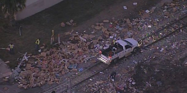 A train colliding with a semi-truck left boxes of meat scattered all over the roadway.