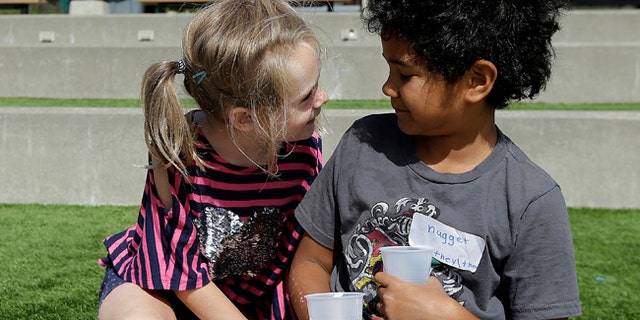 Campers Gracie, left, leans toward Nugget during an activity at the Bay Area Rainbow Day Camp in El Cerrito, Calif., in this July 11, 2017 photo.