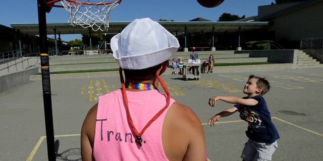 Camp instructor Kris Gambardella watches as camper Wilson shoots baskets at Rainbow Day Camp.