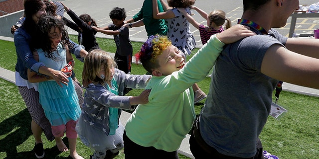 Campers and camp counselors dance at Rainbow Day Camp.