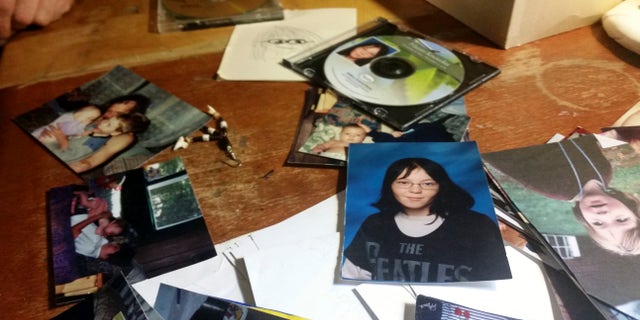 FILE - In this Nov. 16, 2016 file photo, photographs of Charles Knowles, the transgender son of Michelle Knowles, lie scattered on a table in her home in North Vassalboro, Maine. Juvenile detention and correctional facilities nationwide are struggling with how to house and treat transgender youth, who face disproportionate incarceration rates. Charles Knowles, 16, killed himself while temporarily detained at Long Creek Youth Development Center on Nov. 1, in South Portland, Maine. (AP Photo/Marina Villeneuve, File)