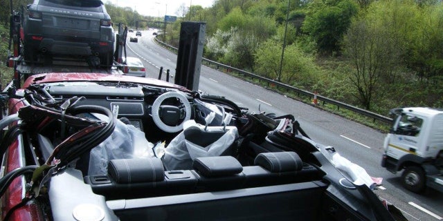 This is what happened when a car transporter collided with a motorway bridge - and accidentally turned a brand new Range Rover into a convertible. See SWNS story SWOOPS; The driver forgot to lower the top deck before travelling along the M61, police said. Fortunately nobody was hurt, but the brand new red car lost its windscreen and windows. But photos show the rest of the car - including the seats, steering wheel and door - remained intact, following the crash near Farnworth, Greater Manchester.