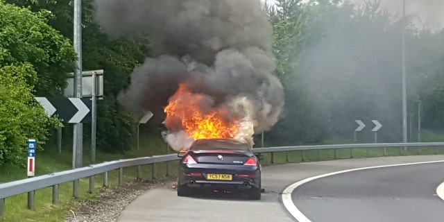 Andrew Lindsay's BMW bursting into flames. A DAD-of-oneâs BMW 6 Series erupted in a fireball on a motorway and trapped him inside the burning car â when the locks jammed. See NTI story NTIBMW. Andrew Lindsay, 45, desperately tried to escape the motor when it burst into flames while he was travelling at 70mph on the M6 Toll Road. He managed to shoulder barge the driverâs door open and leap from the car moments before the engine exploded and melted the tyres to the road. Andrew, a copy editor from Whittington, Staffs., was on his way to see family in North Wales when the blaze broke out on June 1.
