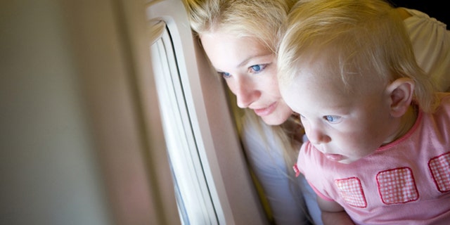 mother and child look through the window of the airplane