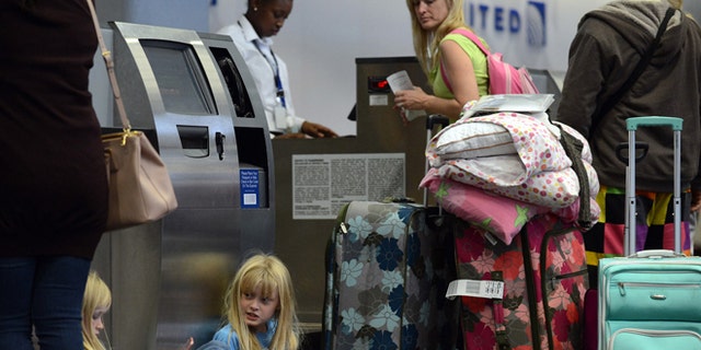 Hunter Crosby, left, 9, and Scout Crosby, 8, play video games as they wait while their parents try to make alternative travel arrangements at San Francisco International Airport. Many flights to the East Coast were canceled due to Hurricane Sandy.