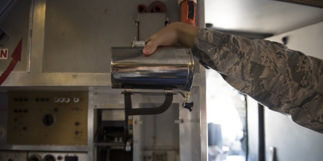 An Airman holds a hot cup inside a KC-10 Extender at Travis Air Force Base, Calif., in June.