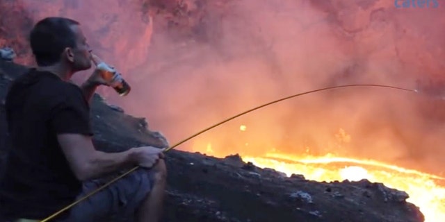 Simon Turner sits by an active lava lake to roast a marshmallow.