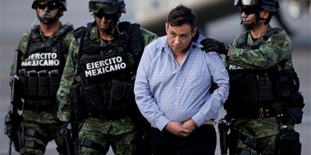 Soldiers escort a man who authorities identified as Omar Trevino Morales, alias "Z-42," leader of the Zetas drug cartel, as he is moved from a military plane to a military vehicle at the Attorney General's Office hangar in Mexico City, Wednesday, March 4, 2015. An official who was not authorized to be quoted by name because of government policy, said Morales was arrested on Wednesday in a pre-dawn raid in San Pedro Garza Garcia, a wealthy suburb of the northern city of Monterrey. (AP Photo/Eduardo Verdugo)