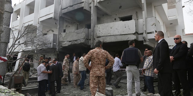 April 23, 2013: Security officers and officials inspect the site of a car bomb that targeted the French embassy wounding two French guards and causing extensive material damage in Tripoli, Libya.