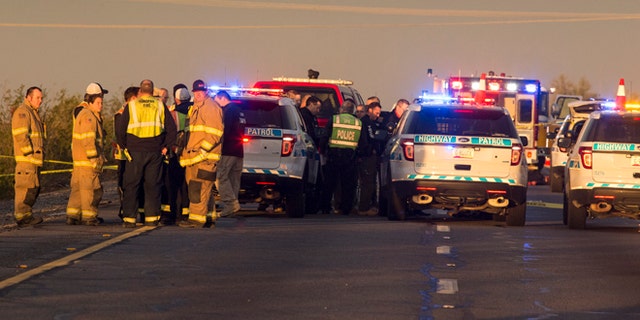 Emergency personnel gather at the scene where an Arizona Department of Public Safety trooper was shot, Thursday, Jan. 12, 2017, at the scene of a rollover accident on Interstate 10 near Tonopah, Ariz.