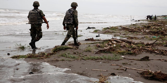 Sept. 10: Navy officers walk along El Bosque beach, in Mexico's Tabasco state. Mexico's state oil company and a Texas-based company searched for 10 missing oil workers on Friday, including four Americans, who evacuated from a research vessel in the Gulf of Mexico ahead of Tropical Storm Nate.