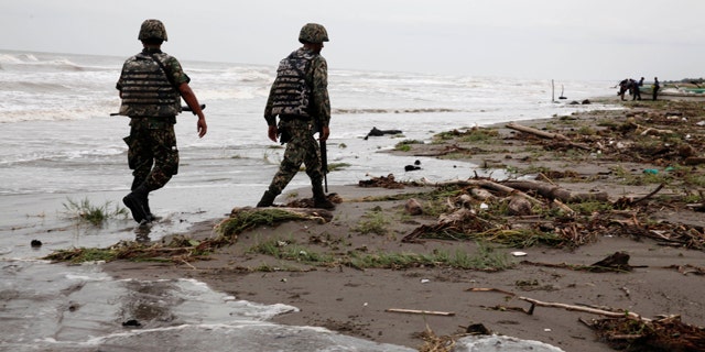 Sept. 10: Navy officers walk along El Bosque beach, in Mexico's Tabasco state. Mexico's state oil company and a Texas-based company searched for 10 missing oil workers on Friday, including four Americans, who evacuated from a research vessel in the Gulf of Mexico ahead of Tropical Storm Nate.