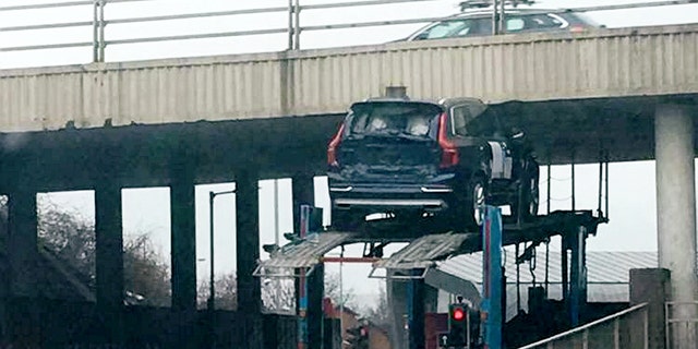 This picture shows the moment a car got stuck under a bridge while on top of a transporter.  See CENTRE PRESS story CPCAR.  Kirsty Adams was driving from her granddadâs funeral at around 3pm on Thursday until she witnessed "a Volvo" trapped underneath the bridge.  According to the 33-year-old, another car fell to the ground as the transporter attempted to drive under the low bridge.  The incident which happened near a roundabout at the Hillington Industrial Estate in Glasgow left the mother-of-one and her partner stunned.
