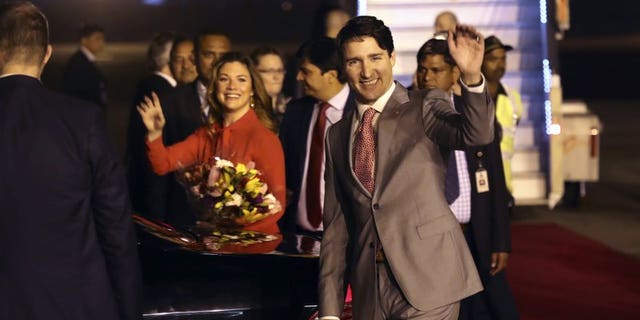 Canadian Prime Minister Justin Trudeau and his wife, Sophie Gregoire Trudeau, wave upon their arrival in New Delhi, India, Feb. 17, 2018.