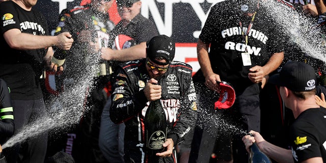 Martin Truex Jr., center, celebrates after winning the NASCAR Cup Series auto race, Sunday, Aug. 6, 2017, in Watkins Glen, N.Y. (AP Photo/Matt Slocum)