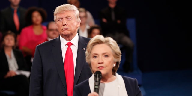 Republican U.S. presidential nominee Donald Trump listens as Democratic nominee Hillary Clinton answers a question from the audience during their presidential town hall debate at Washington University in St. Louis, Missouri, U.S., October 9, 2016. REUTERS/Rick Wilking - RTSRIR9