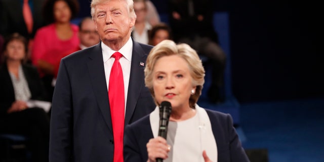Republican U.S. presidential nominee Donald Trump listens as Democratic nominee Hillary Clinton answers a question from the audience during their presidential town hall debate at Washington University in St. Louis, Missouri, U.S., October 9, 2016. REUTERS/Rick Wilking - RTSRIR9
