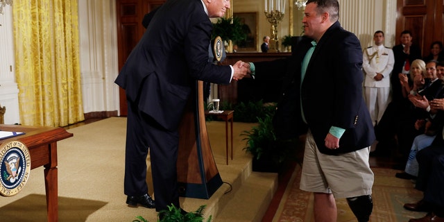 U.S. President Donald Trump shakes hands with Sgt. Michael Verardo, who lost a leg in an IED explosion in Afghanistan, before signing the âVA Accountability Actâ in the East Room of the White House in Washington, U.S., June 23, 2017. REUTERS/Jonathan Ernst - RTS18DN8